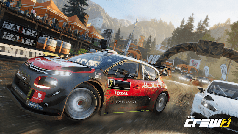 Two muddy cars race on a track in the mountains.