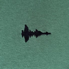 Airwiggles T-shirt with an embroidered sound wave of Lewis saying 'this is a t-shirt'