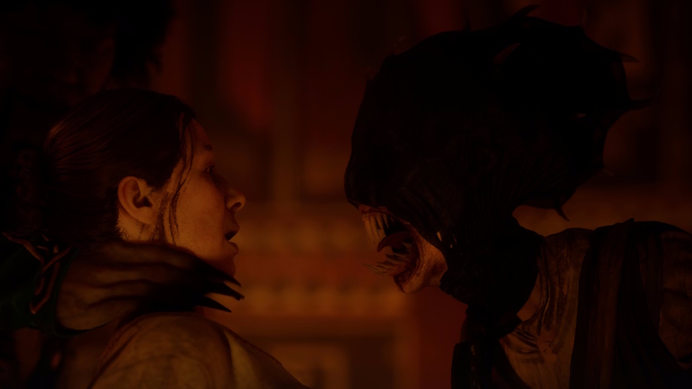 A vampire leans in close to a frightened woman in a dim, red-lit room